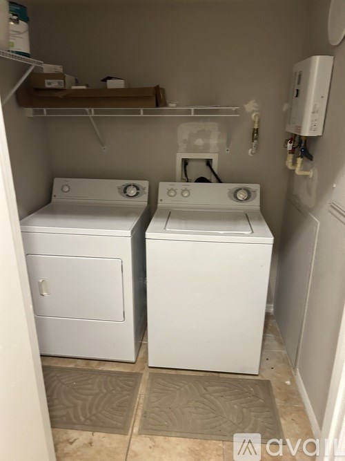 A small laundry room with a washer and dryer.