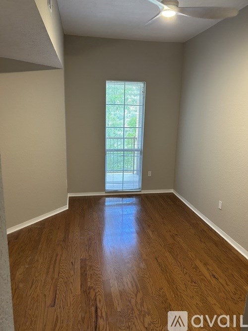 A room with wooden flooring and a window.