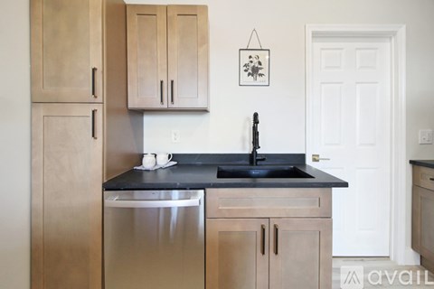 A kitchen with wooden cabinets and a black countertop.