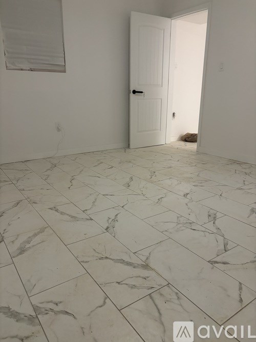 A room with a marble floor and a white door.