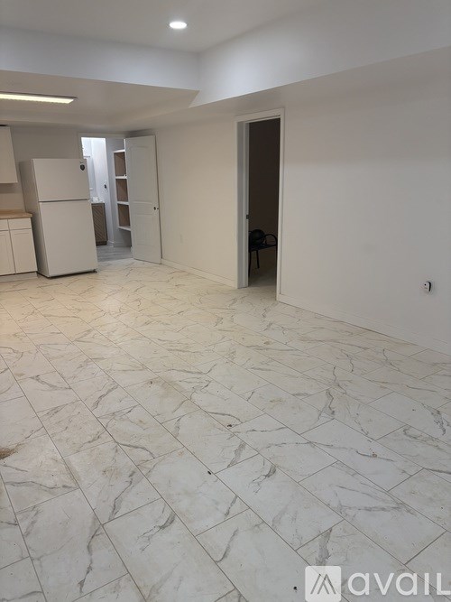 A spacious room with marble flooring and white walls.