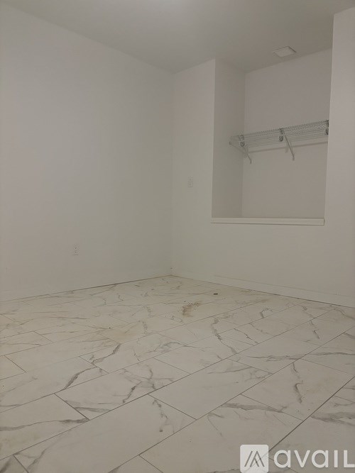 A room with a marble floor and a white wall.