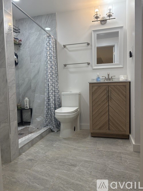 A bathroom with a toilet, sink, and shower.