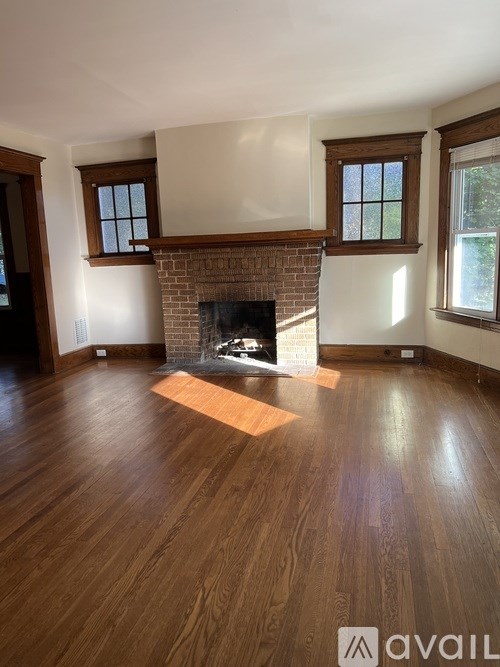 A living room with a fireplace and wood flooring.