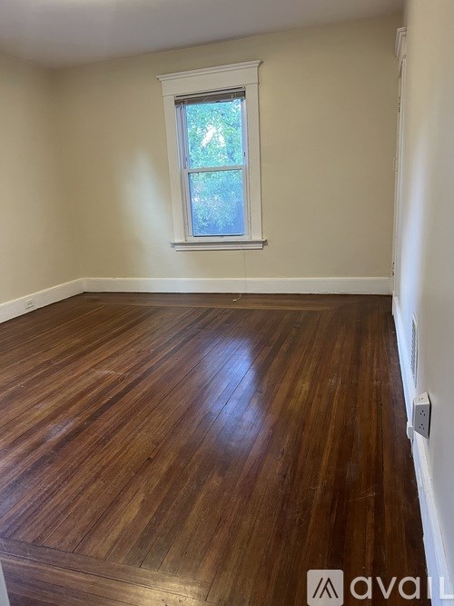 A room with wooden flooring and a window.