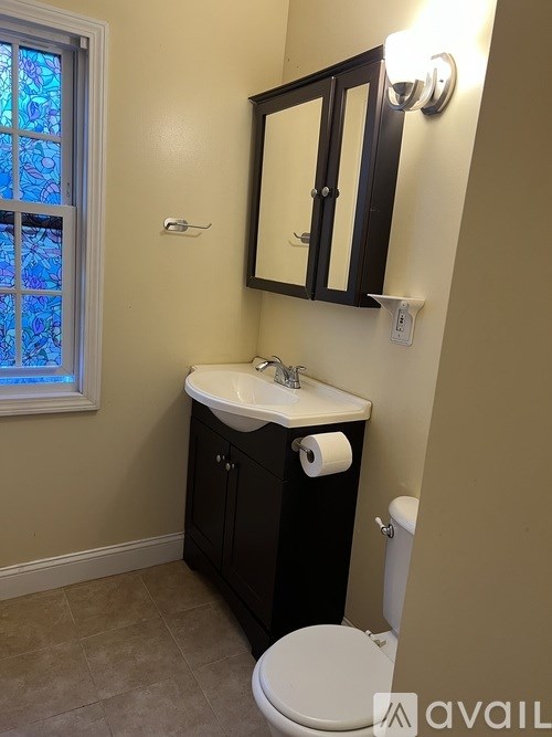 A bathroom with a sink, toilet and mirror.