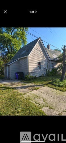 A house with a grey roof and a white wall is shown.