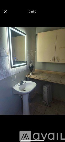 A bathroom with a white pedestal sink and a mirror above it.