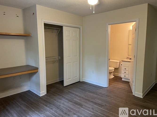 A room with a toilet, sink and a shelf.