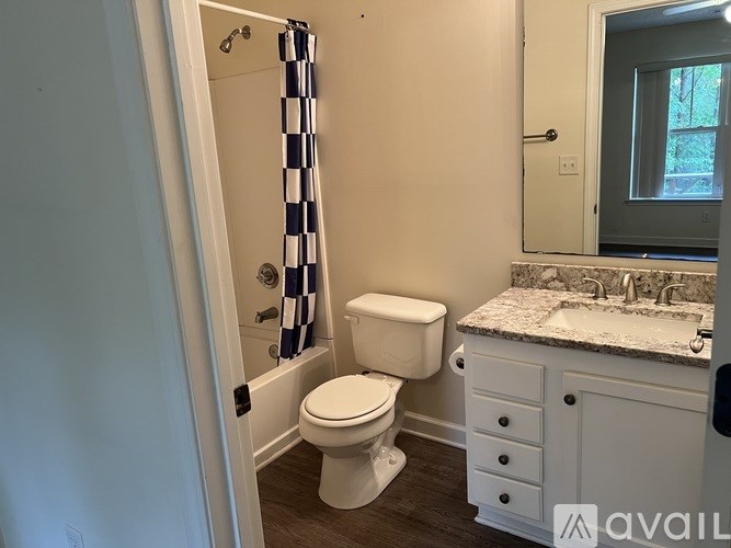 A bathroom with a toilet, sink, and shower.