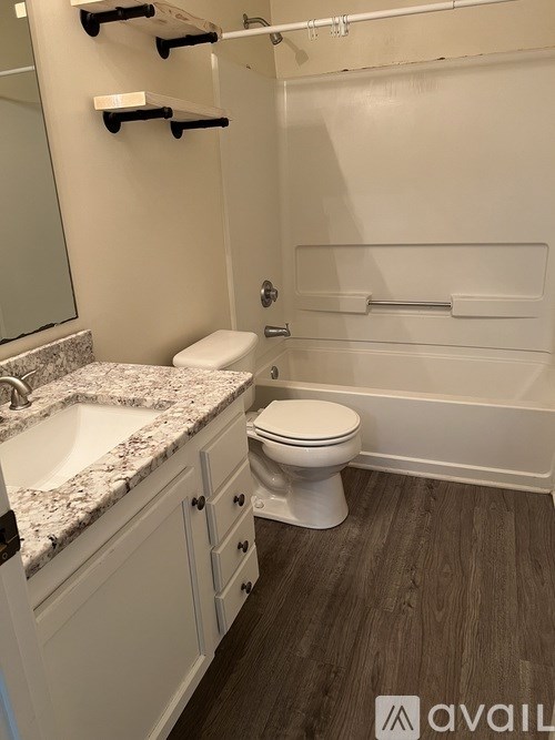 A bathroom with a toilet, sink, and shelves.