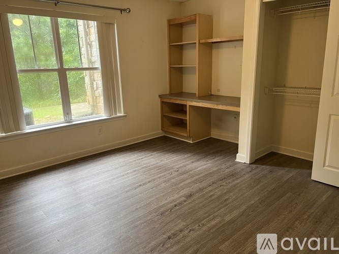 A room with a window and a shelving unit.