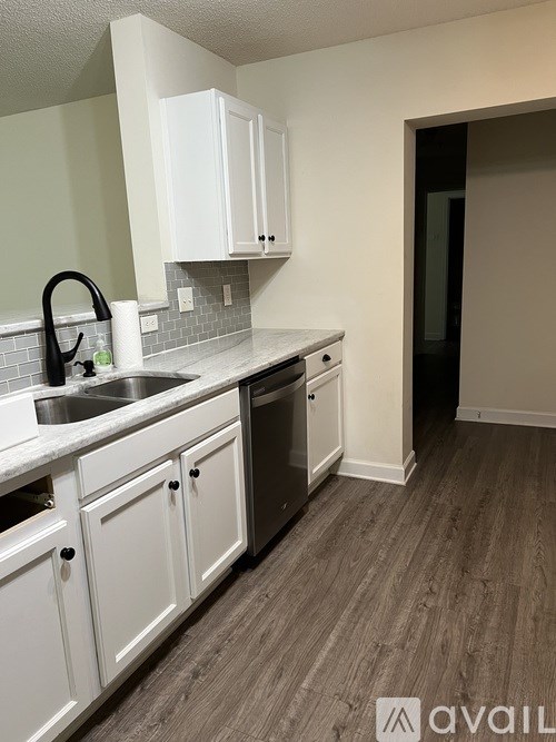 A kitchen with white cabinets and a sink.