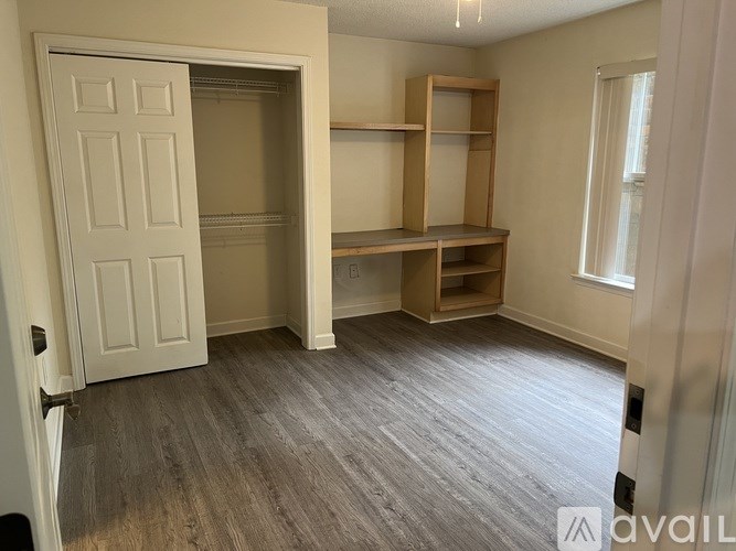A room with a white door and a wooden shelf unit.