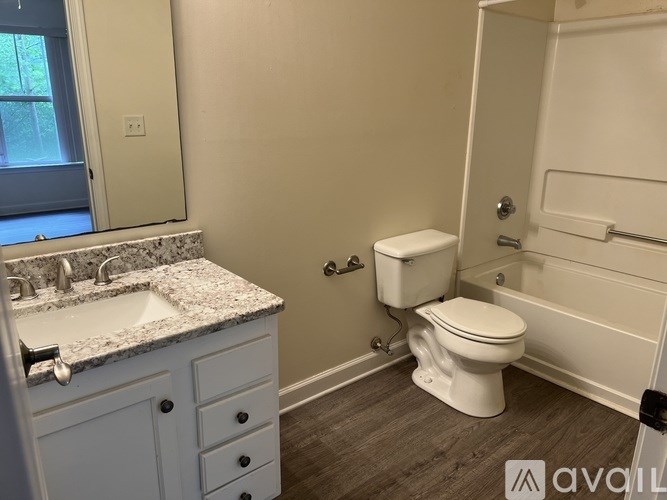 A white toilet sits next to a bathtub in a bathroom.