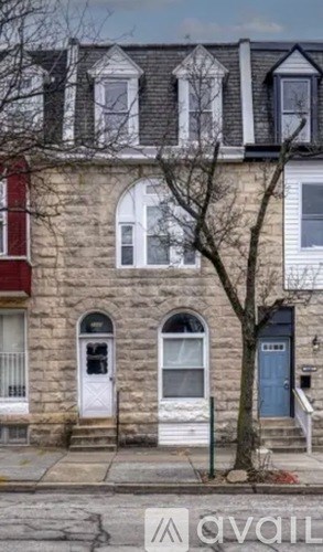 A stone building with a tree in front of it.