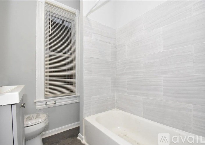 A white bathroom with a tub, toilet and sink.