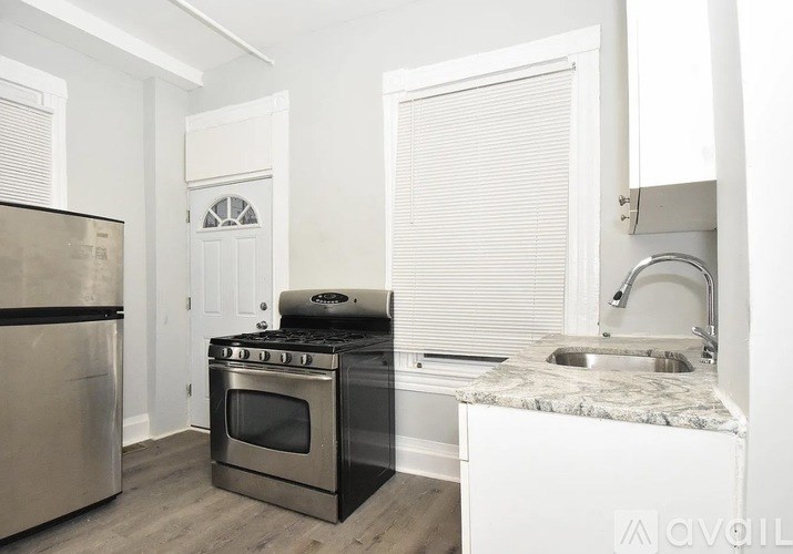 A kitchen with a stove, oven, and sink.