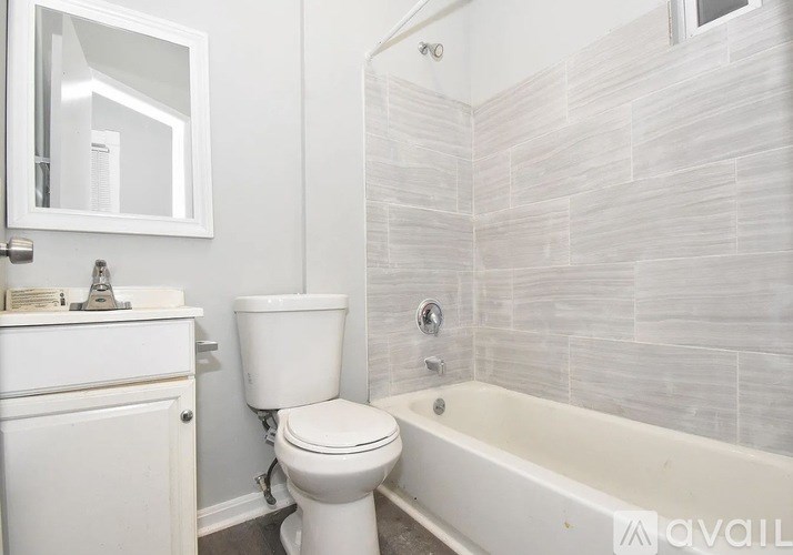 A white toilet sits next to a bathtub in a bathroom.
