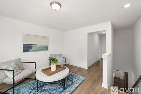 A living room with a couch, coffee table, and a painting on the wall.