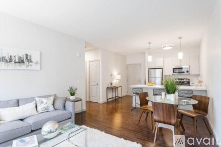 A living room with a grey couch and a glass coffee table.