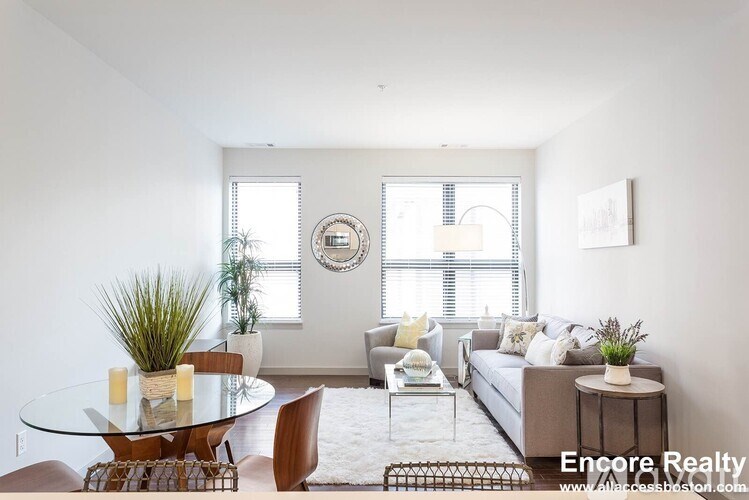 A modern living room with a glass table and a couch.