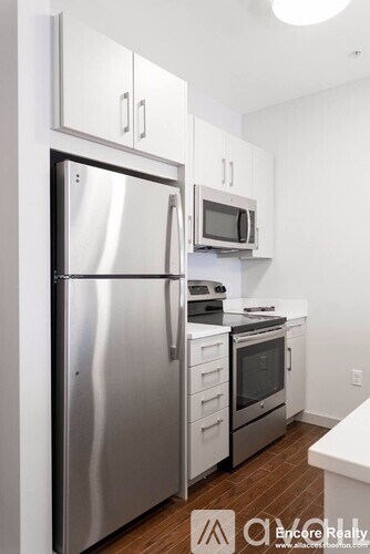 A modern kitchen with stainless steel appliances and white cabinets.