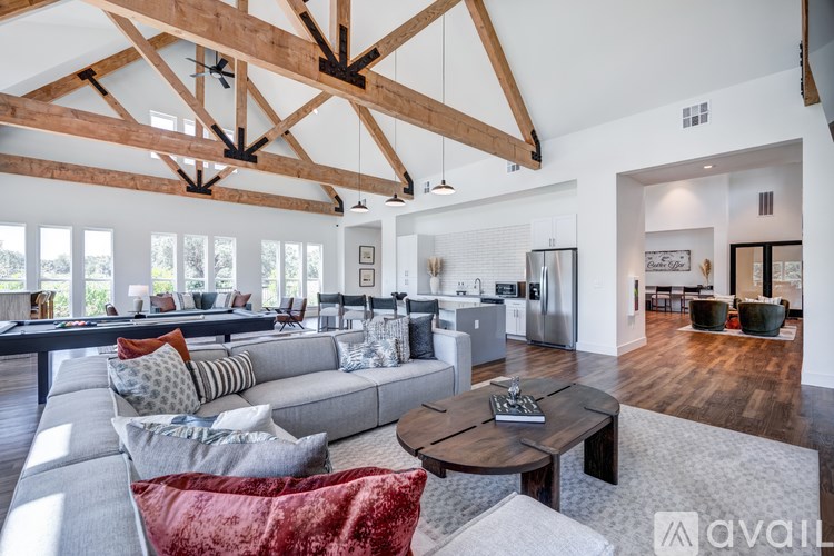 A spacious living room with a grey sofa and a wooden coffee table.