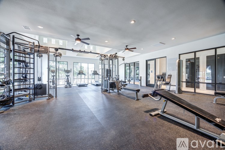 A spacious gym with a variety of equipment and a large mirrored wall.