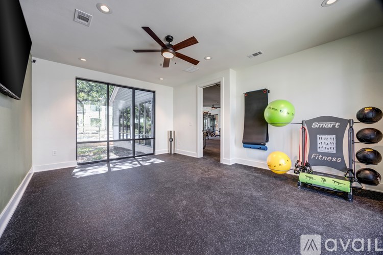 A room with a ceiling fan and a wall-mounted speaker.