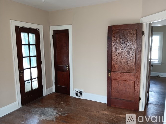A room with a brown door and a window with blinds.