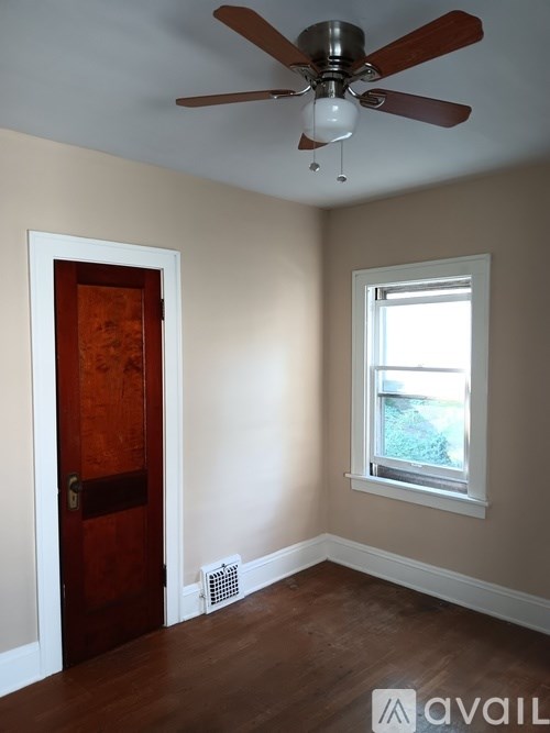 A room with a ceiling fan and a window.