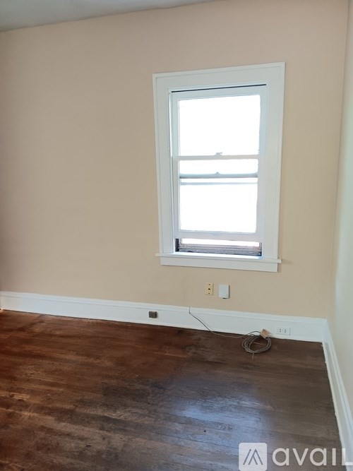 A room with a window and wooden floor.