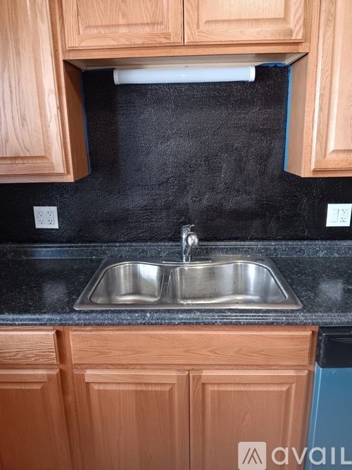 A kitchen with wooden cabinets and a black countertop.