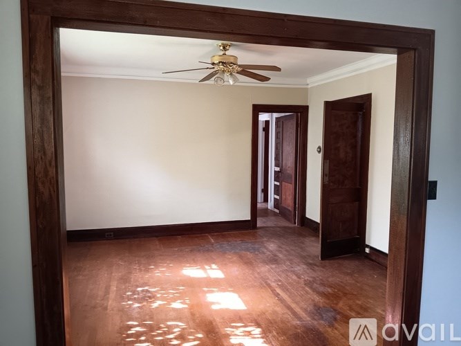A room with a ceiling fan and wooden floors.