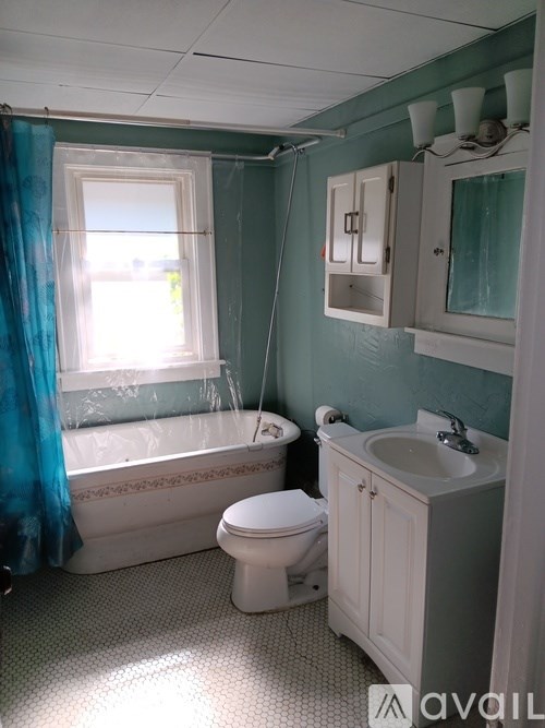 A bathroom with a toilet, sink, and bathtub.