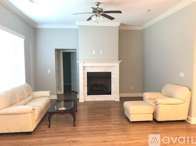 A living room with a fireplace and a ceiling fan.