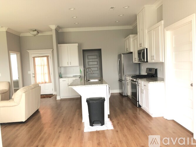A kitchen with white cabinets and a black fridge.