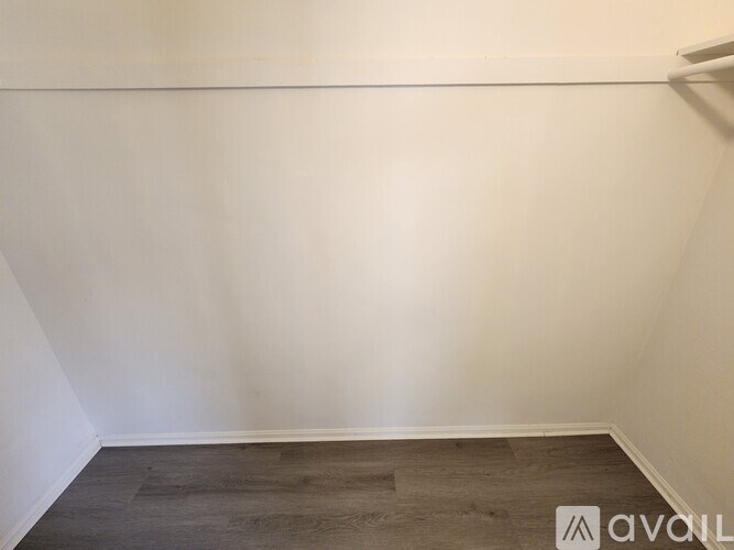 A room with white walls and a wooden floor.