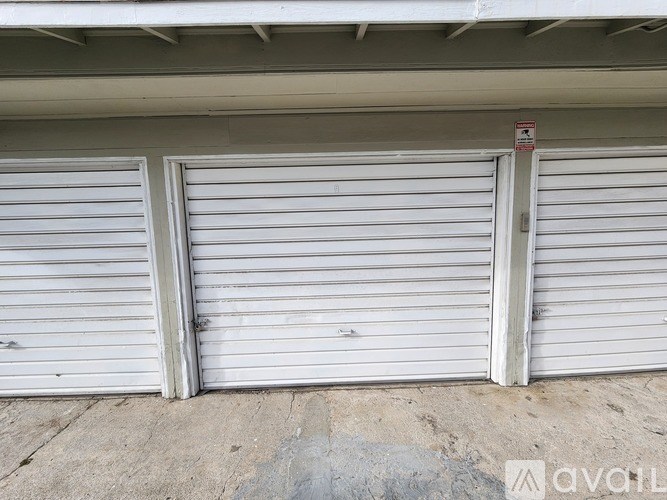 Two white garage doors closed with a red sign above them.