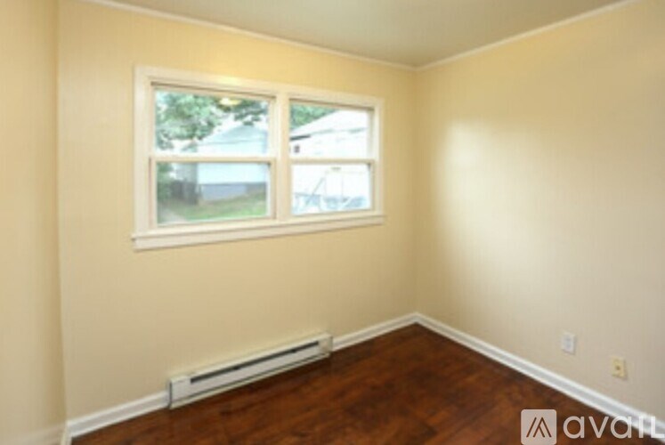 A room with a window and a wall-mounted air conditioner.