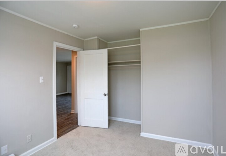 A room with a white door and a carpeted floor.