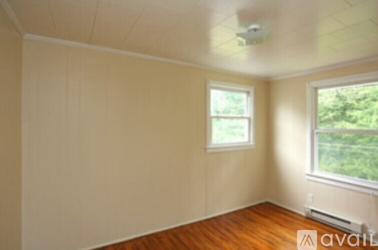 A room with a window and a wooden floor.