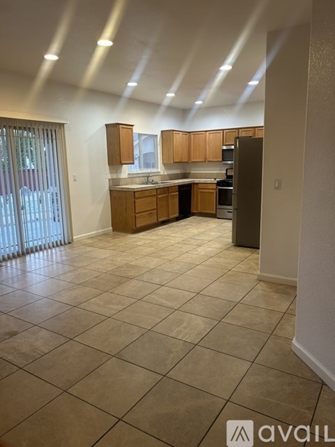 A kitchen with wooden cabinets and a tiled floor.