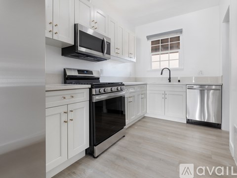 A kitchen with white cabinets and a black stove top oven.