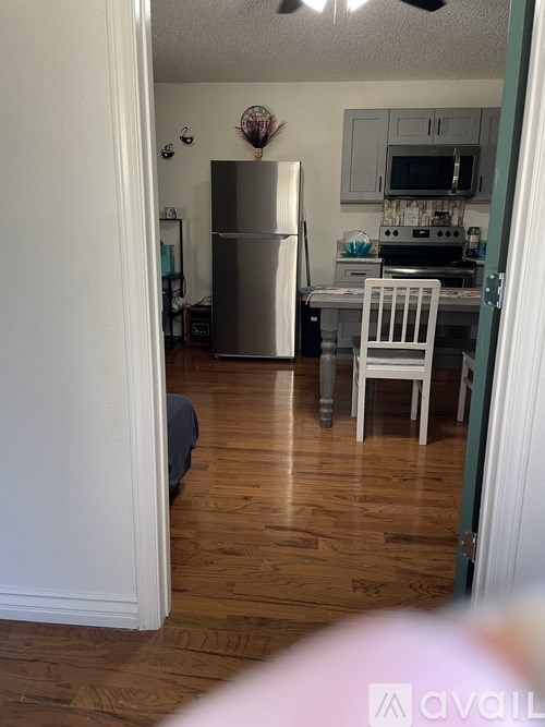 A kitchen with a refrigerator, microwave, and oven.