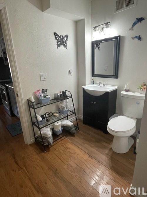 A bathroom with a white toilet, sink, and a butterfly decoration on the wall.