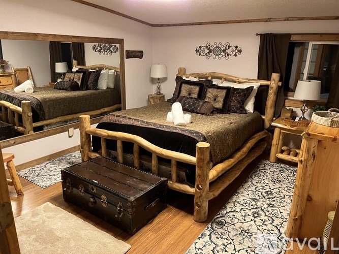 A bedroom with two beds and a wooden bench.