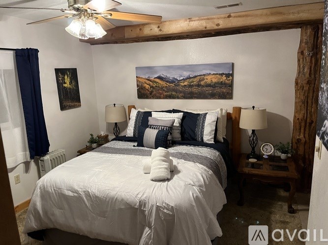 A bedroom with a large bed and a painting on the wall.