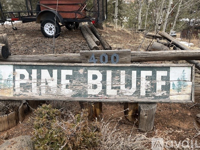 A wooden sign that says Pine Bluff stands in front of a trailer.